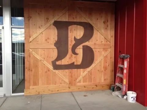 Paint Bro’z Inc. commercial project — a wood-paneled storefront wall with a large stained letter B.