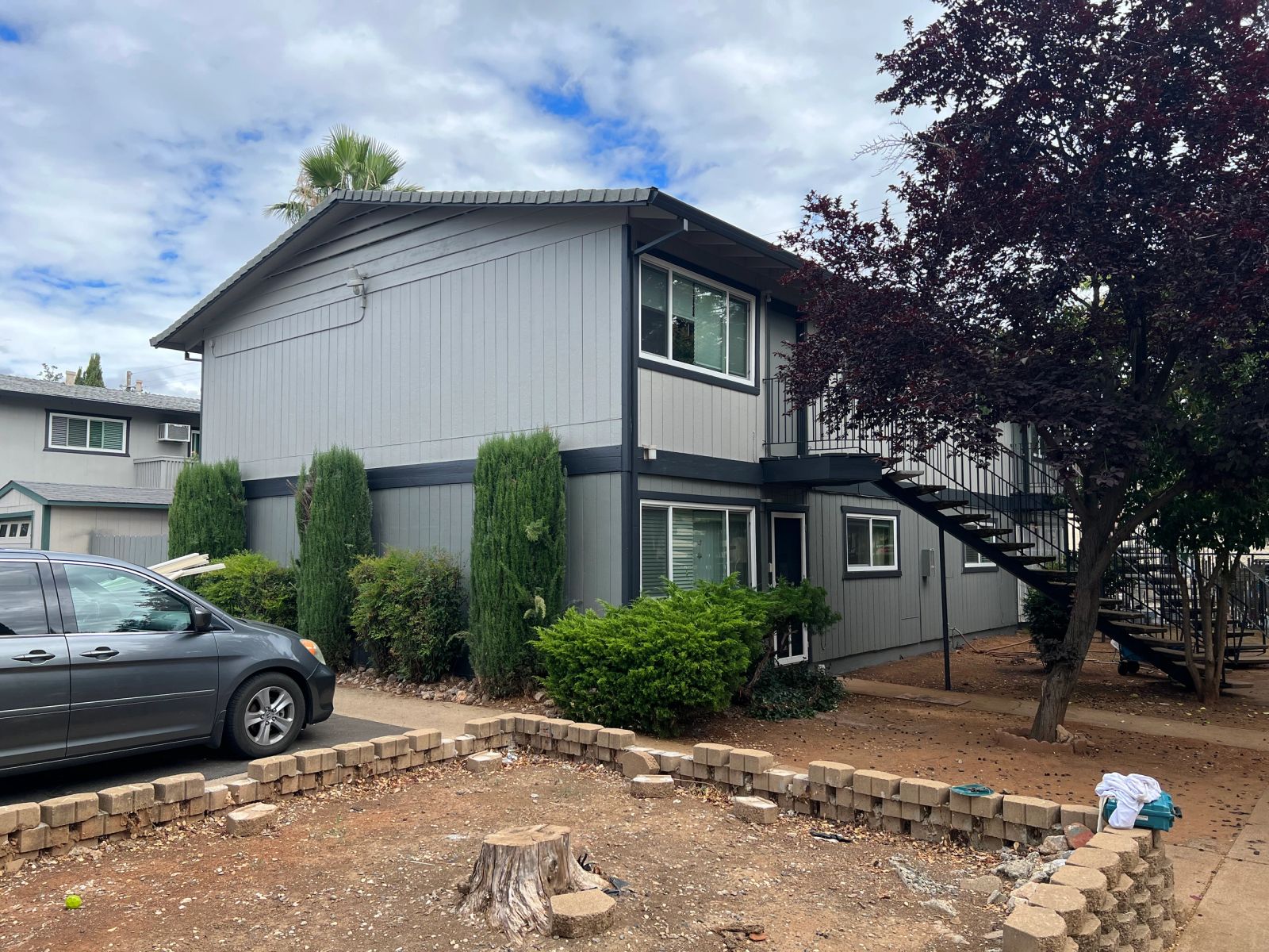 Two-story apartment building repainted in gray with dark trim by Paint Bro’z Inc.
